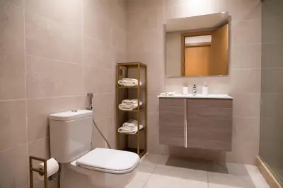 a bathroom with a toilet and a sink and a mirror at 2BR Prestigia Hay Riad 13 mintues city center in Rabat