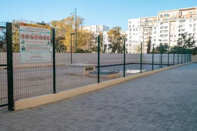 a fence in front of a building with a park at 2BR Prestigia Hay Riad 13 mintues city center in Rabat