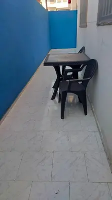 a wooden table and a bench sitting on a tile floor at Dar Indigo in Temara