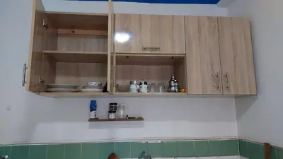 a kitchen with wooden cabinets with dishes on it at Dar Indigo in Temara