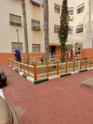 a fence with trees in front of a building at Dar Indigo in Temara