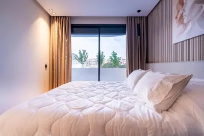a large white bed in a bedroom with a window at Appartement luxueux plein centre Casablanca - 2 Personnes in Casablanca