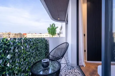 a balcony with a glass table and chair on a balcony at Appartement luxueux plein centre Casablanca - 2 Personnes in Casablanca