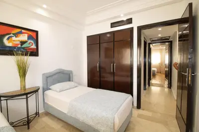 a bedroom with a bed and a table and a door at Horizon Mogador home in Casablanca