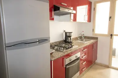 a kitchen with red cabinets and a refrigerator at Horizon Mogador home in Casablanca