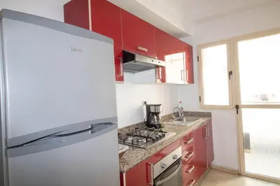 a white refrigerator in a kitchen with red cabinets at Horizon Mogador home in Casablanca