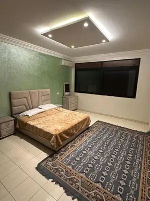a bedroom with a bed and a large flat screen tv at appartement a 1 min de la plage in Casablanca