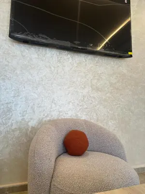a stuffed animal sitting on a chair with a tv on the wall at appartement a 1 min de la plage in Casablanca