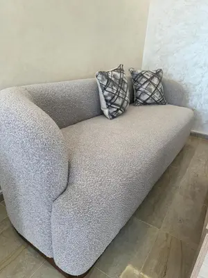 a gray couch with two pillows on top of it at appartement a 1 min de la plage in Casablanca