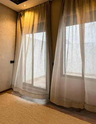 two windows with white curtains in a room at Appart familial cœur Casa in Casablanca