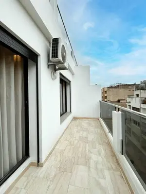 a balcony of a white building with a fan at Appart familial cœur Casa in Casablanca