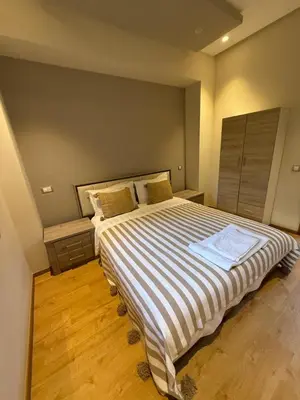 a bedroom with a large bed with striped sheets at Studio Perla Sofé in Nouaseur