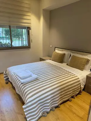 a bedroom with a large bed with a striped blanket at Studio Perla Sofé in Nouaseur