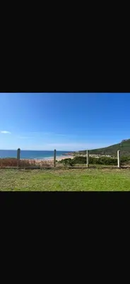 a view of the ocean from a field with a fence at Marbella Beach apartement holiday 2 chambres,piscine et plage in Mansouria