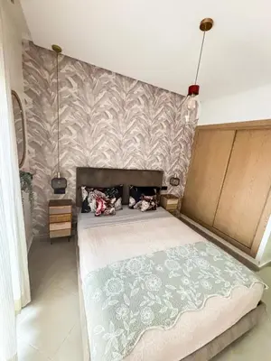 a bedroom with a large bed with a wall at Escapade Tropicale at Jardins Cherrat in Bouznika Bay in Bouznika