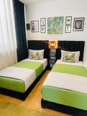 two beds in a room with green and white at Escapade Tropicale at Jardins Cherrat in Bouznika Bay in Bouznika
