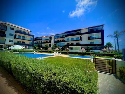a large apartment building with a swimming pool at Escapade Tropicale at Jardins Cherrat in Bouznika Bay in Bouznika
