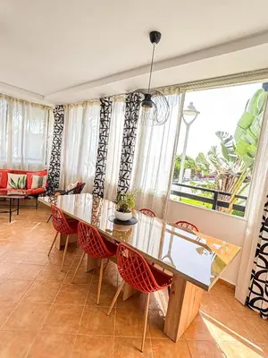 a dining room with a table and chairs at Escapade Tropicale at Jardins Cherrat in Bouznika Bay in Bouznika