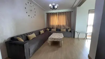 a living room with a couch and a table at Yasmine Beach in Mansouria