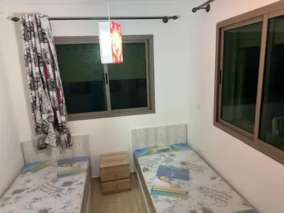 a bedroom with two beds and a window at Yasmine Beach in Mansouria