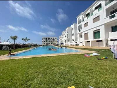 a large swimming pool in front of a building at Yasmine Beach in Mansouria