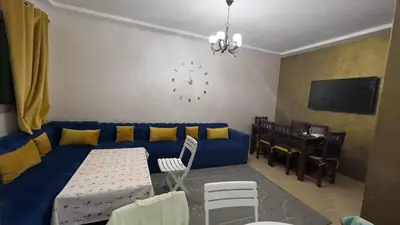 a living room with a blue couch and a table at Yasmine Beach in Mansouria