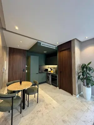 a living room with a table and chairs and a kitchen at Luxury Studio Oasis in Casablanca