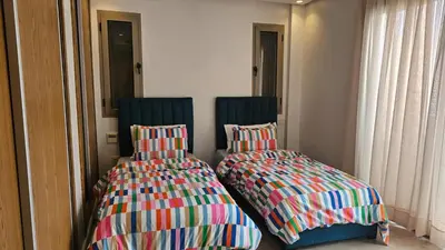 two beds sitting next to each other in a room at Bright 2BR Apartment in Maârif, Ideal for Families & Business Travelers in Casablanca