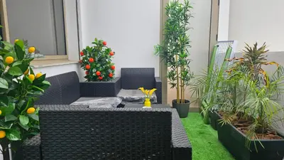 a patio with two wicker chairs and a christmas tree at Bright 2BR Apartment in Maârif, Ideal for Families & Business Travelers in Casablanca