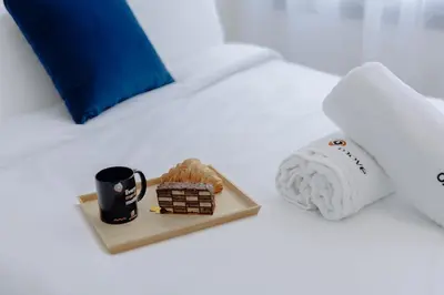 a tray of food and a cup of coffee on a bed at The Shelter Residence by GoodMove - Bourgogne, Casablanca in Casablanca