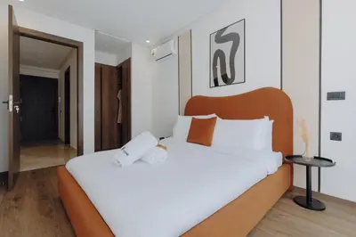 a bedroom with a large white bed with a wooden headboard at The Shelter Residence by GoodMove - Bourgogne, Casablanca in Casablanca