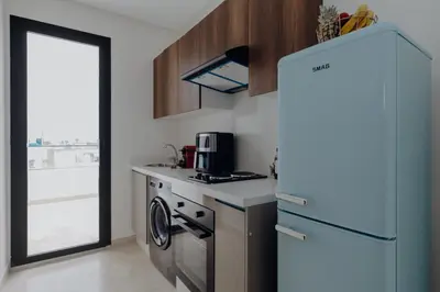 a small kitchen with a refrigerator and a stove at The Shelter Residence by GoodMove - Bourgogne, Casablanca in Casablanca