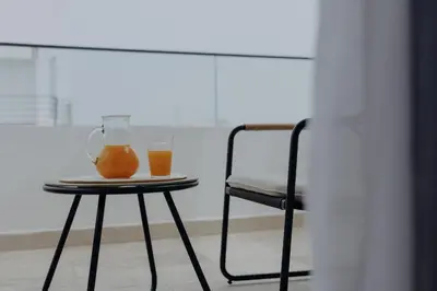 a table with a chair and two drinks on it at The Shelter Residence by GoodMove - Bourgogne, Casablanca in Casablanca