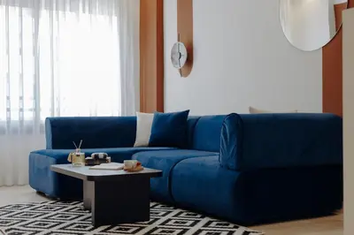 a blue couch in a living room with a table at The Shelter Residence by GoodMove - Bourgogne, Casablanca in Casablanca