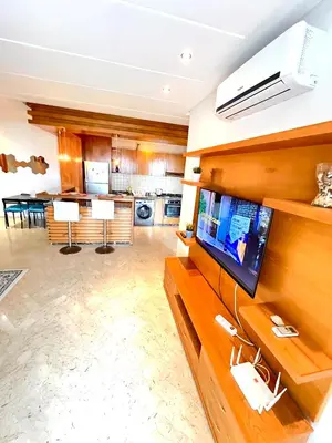 a living room with a flat screen tv on a wall at Seaside appartment with private pool in Tamaris