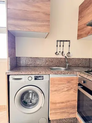 a kitchen with a washing machine and a sink at Bright Apt with Balcony, WiFi, Parking and Pool Resort in Bouznika
