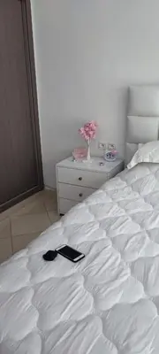 a white bed with a black book on it at Al yakoute in Mansouria