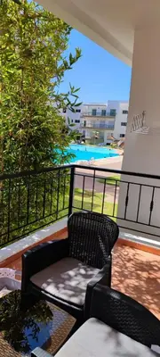 a chair on a balcony with a view of a pool at Al yakoute in Mansouria