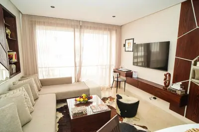 a living room with a couch and a television at Domaine d'Anfa - Luxe & Mer in Casablanca