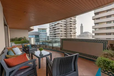 a balcony with chairs and a table with a view of buildings at شقة فاخرة - Luxury apartment in Casablanca