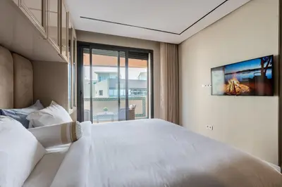 a bedroom with a large white bed and a window at شقة فاخرة - Luxury apartment in Casablanca