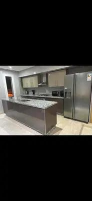 a large kitchen with a stainless steel refrigerator at Plage manesmann in Mohammedia
