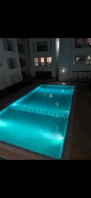 a swimming pool with blue lights in a building at Plage manesmann in Mohammedia