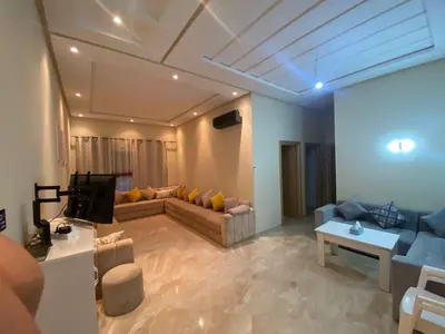 a living room with a couch and a tv at Appartement de haut standing,4 piscines in Bouznika