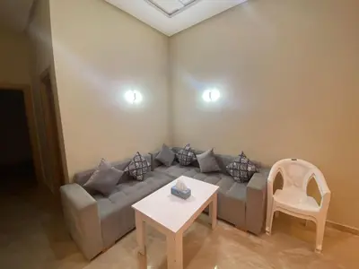 a living room with a couch and a table at Appartement de haut standing,4 piscines in Bouznika