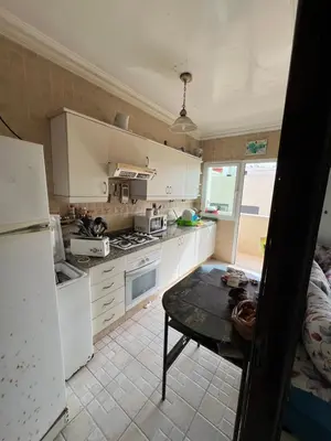 a kitchen with white cabinets and a table in it at Chambre zuiten in Casablanca