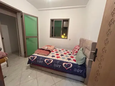a bed sitting in a room with a window at Appartement meublé calme et chaleureuse in Temara