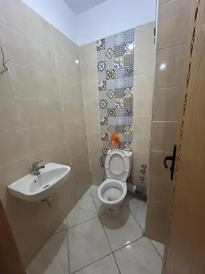 a bathroom with a toilet and a sink at Appartement meublé calme et chaleureuse in Temara