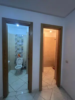 a bathroom with a toilet and a glass door at Appartement meublé calme et chaleureuse in Temara