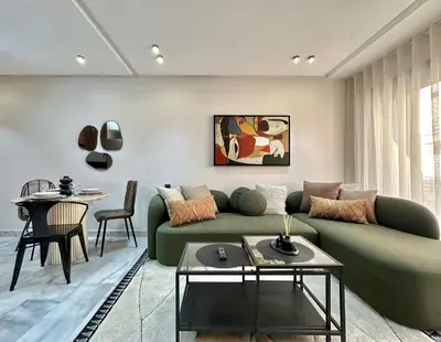 a living room with a green couch and a table at NESK STAY Maarif - ARENA 41 in Casablanca